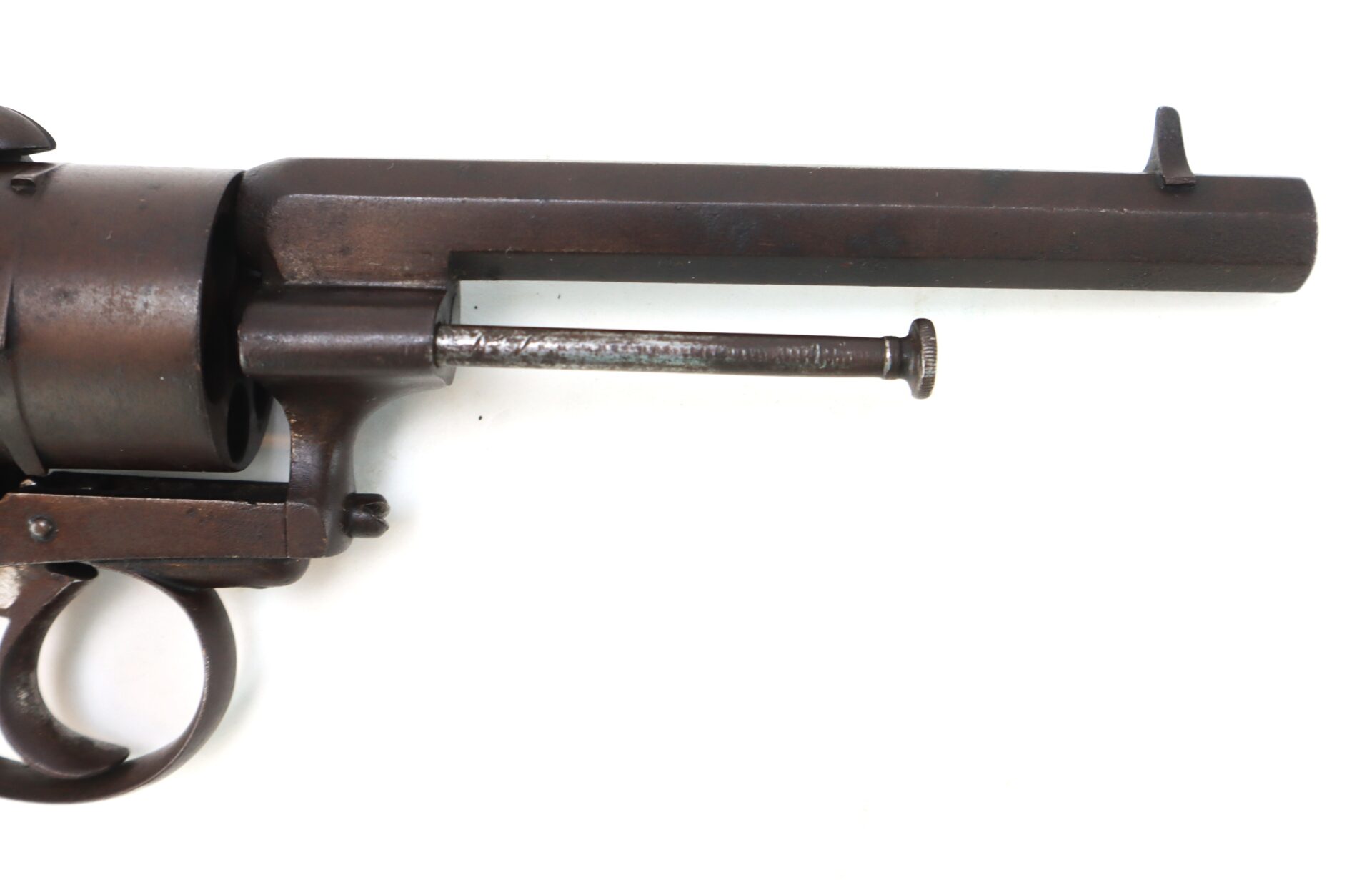 Close-up of the barrel and part of the cylinder of a vintage revolver, showing its trigger and an ejector rod beneath the barrel.
