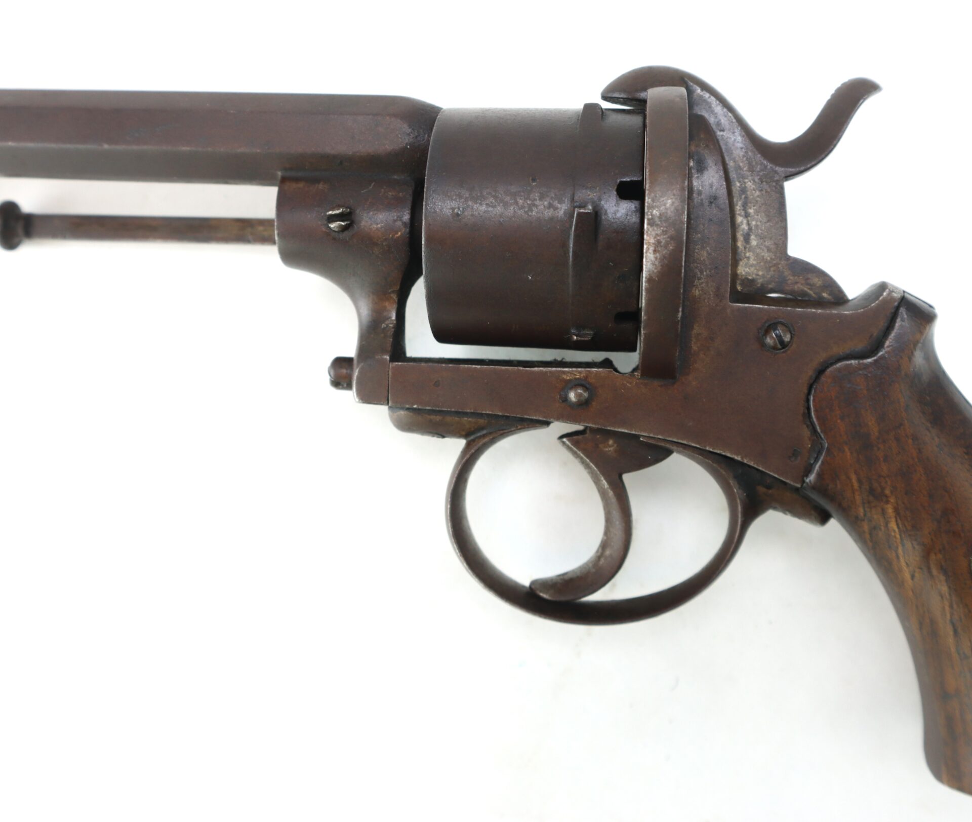 Close-up of an old, rusted revolver with a wooden grip, showing the trigger, cylinder, and part of the barrel against a white background.