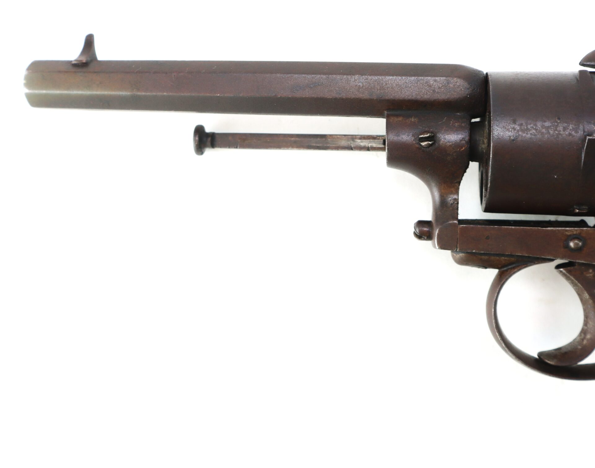Close-up of an antique revolver showing the barrel, trigger, and part of the cylinder against a white background.