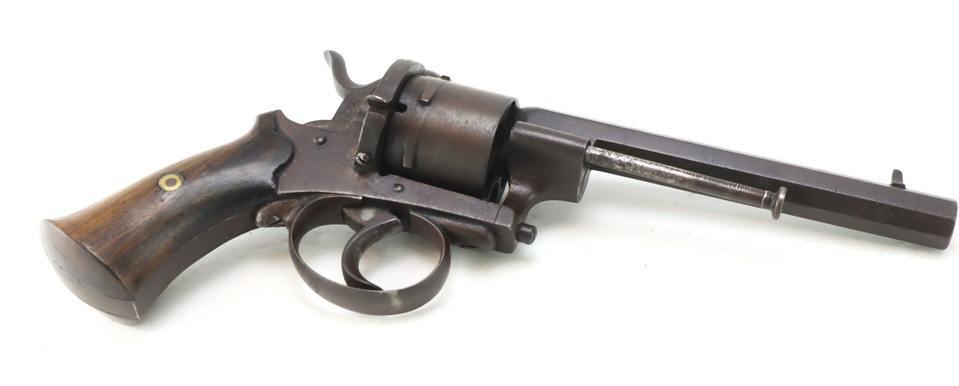 Antique revolver with a wooden grip, large trigger guard, and octagonal barrel, displayed on a plain white background.