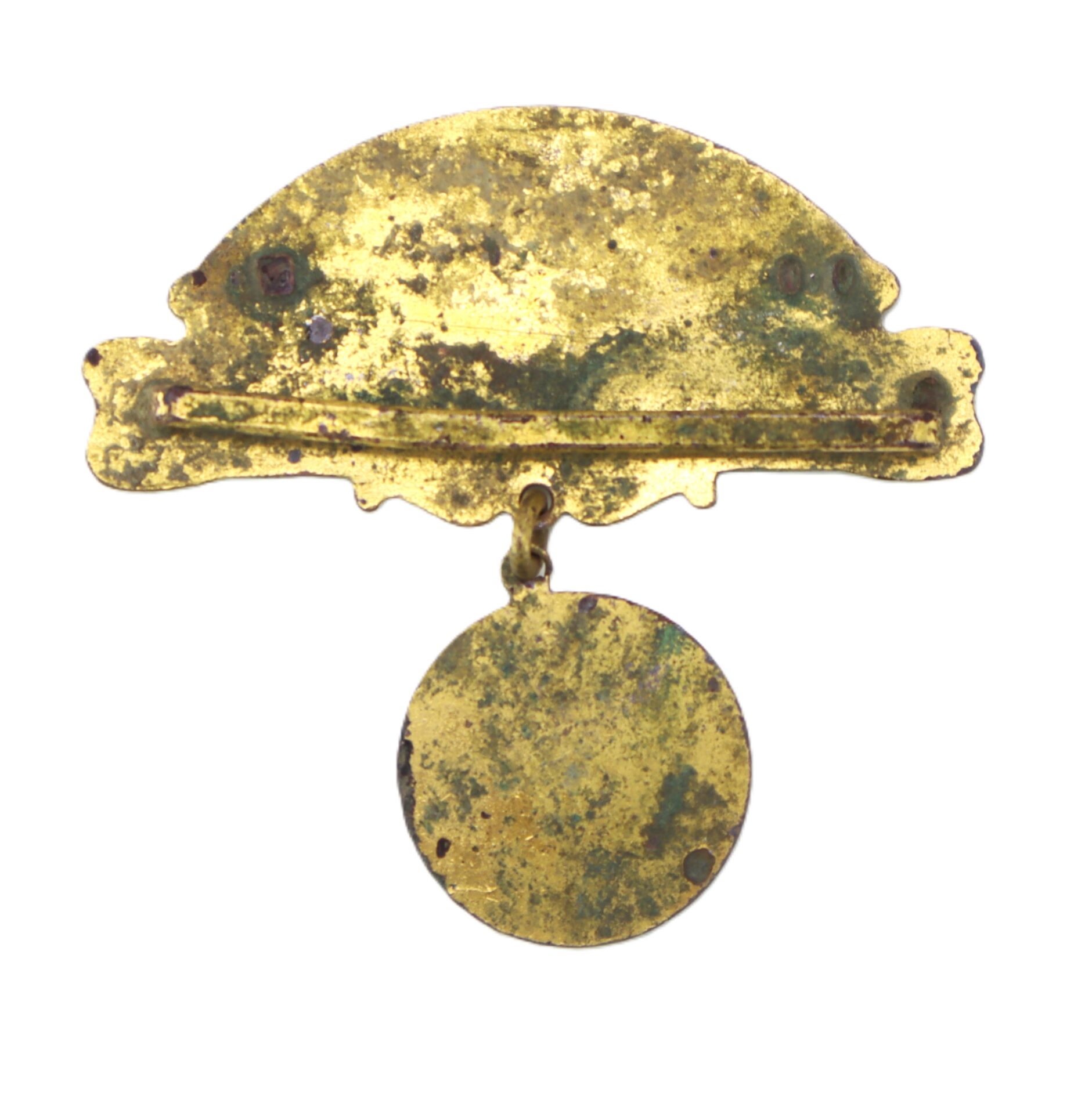 A tarnished, gold-colored metal pin with a semicircular top plate and a round dangling disc, showing signs of age and wear.