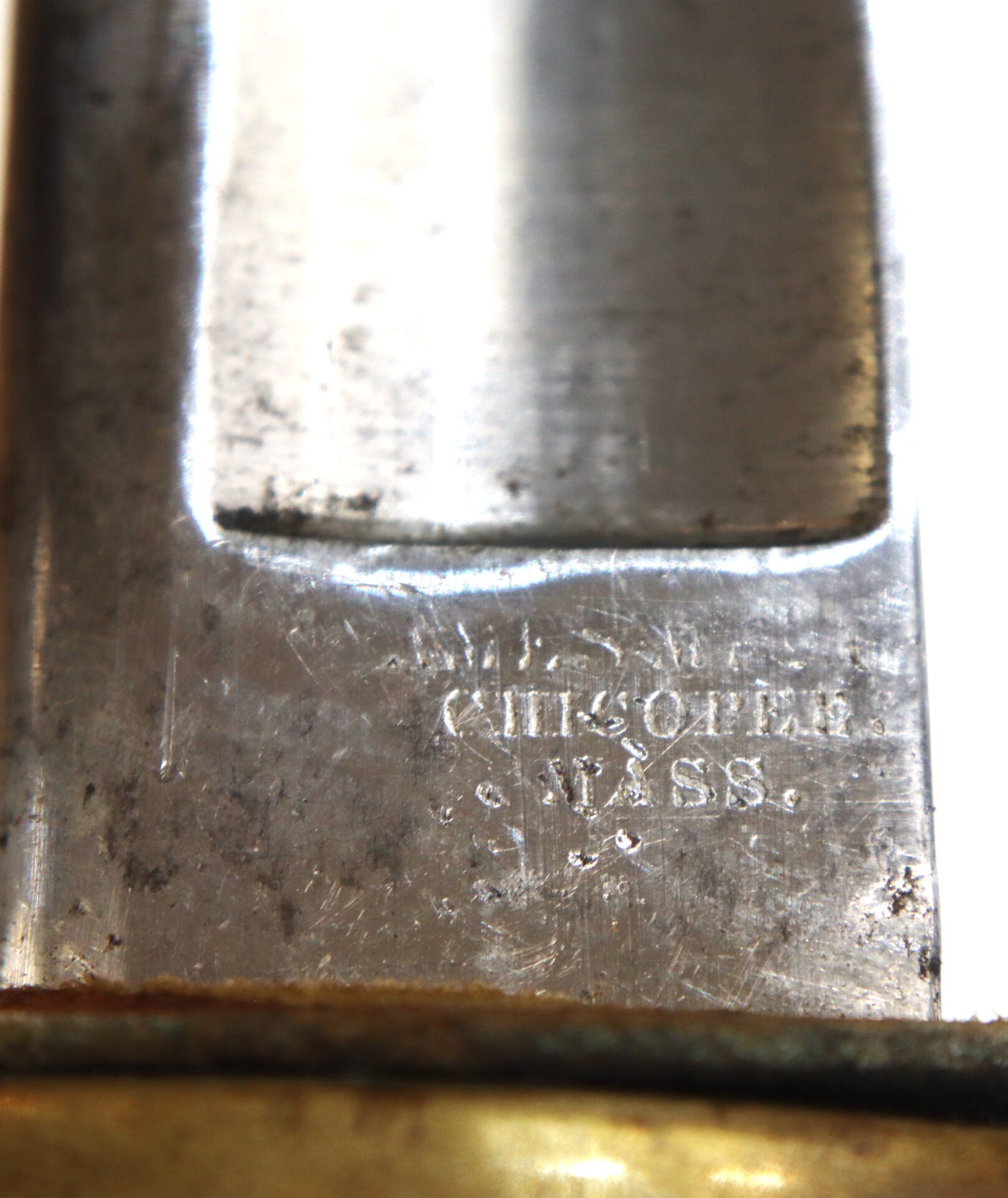 Close-up of an engraved metal blade with the inscription "CHRISTOPHER / WISS" partially visible, showing some tarnish and wear.