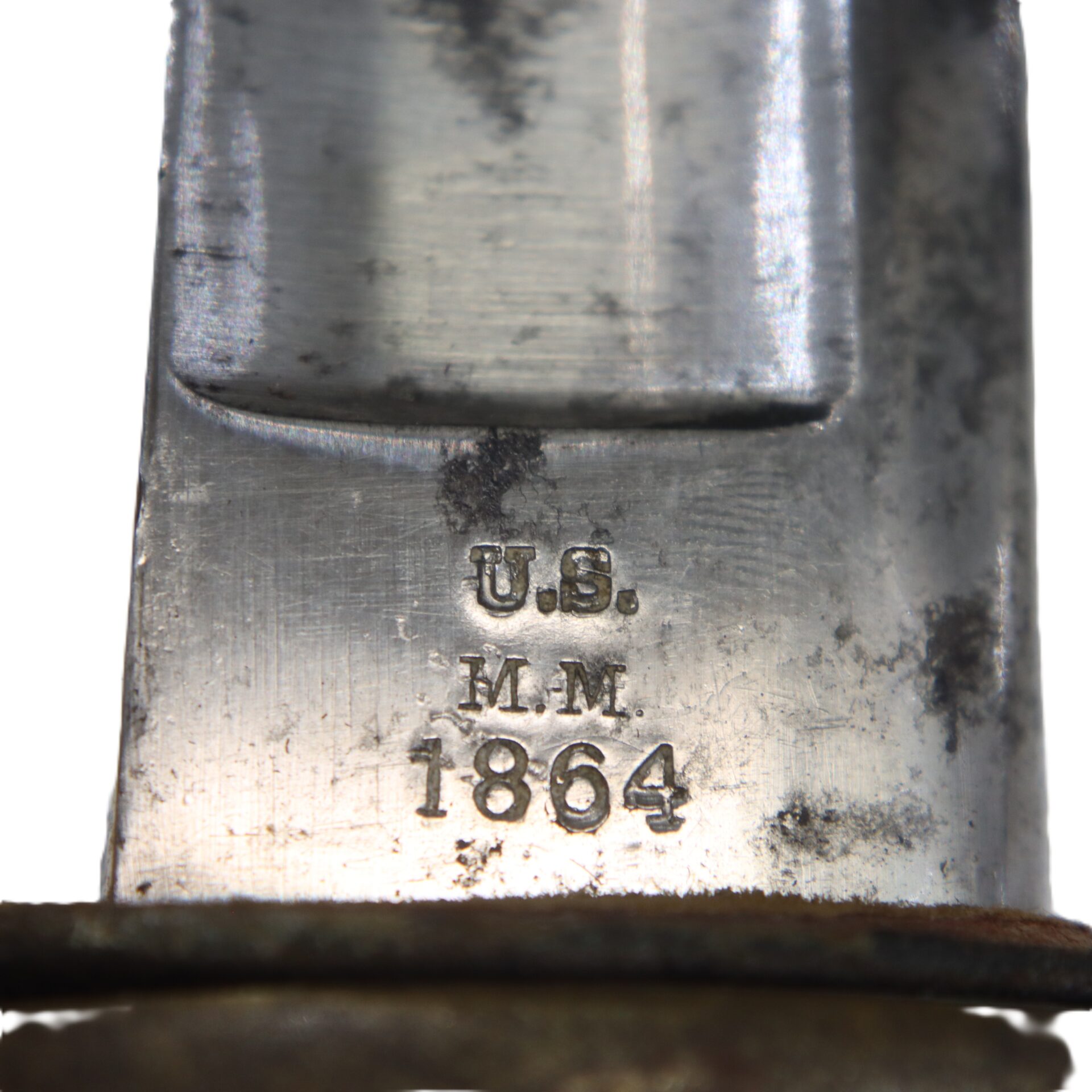 Close-up of a metal blade stamped with “U.S. M.M. 1864,” showing signs of wear and age.