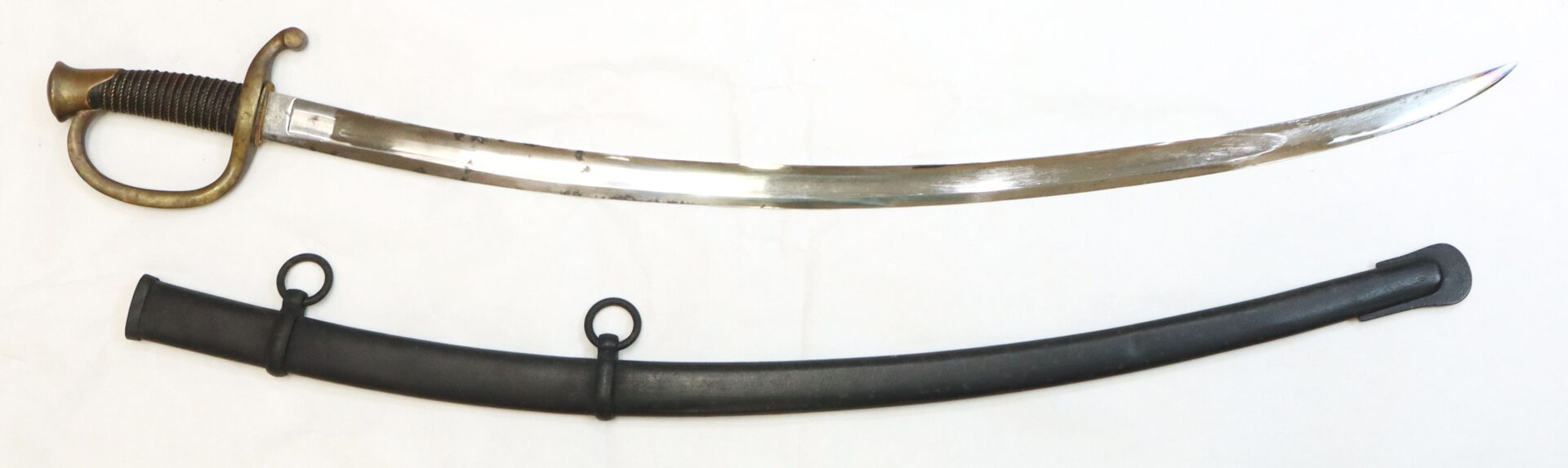 A curved, single-edged saber with a brass guard and black grip, shown alongside its black scabbard with two metal rings.
