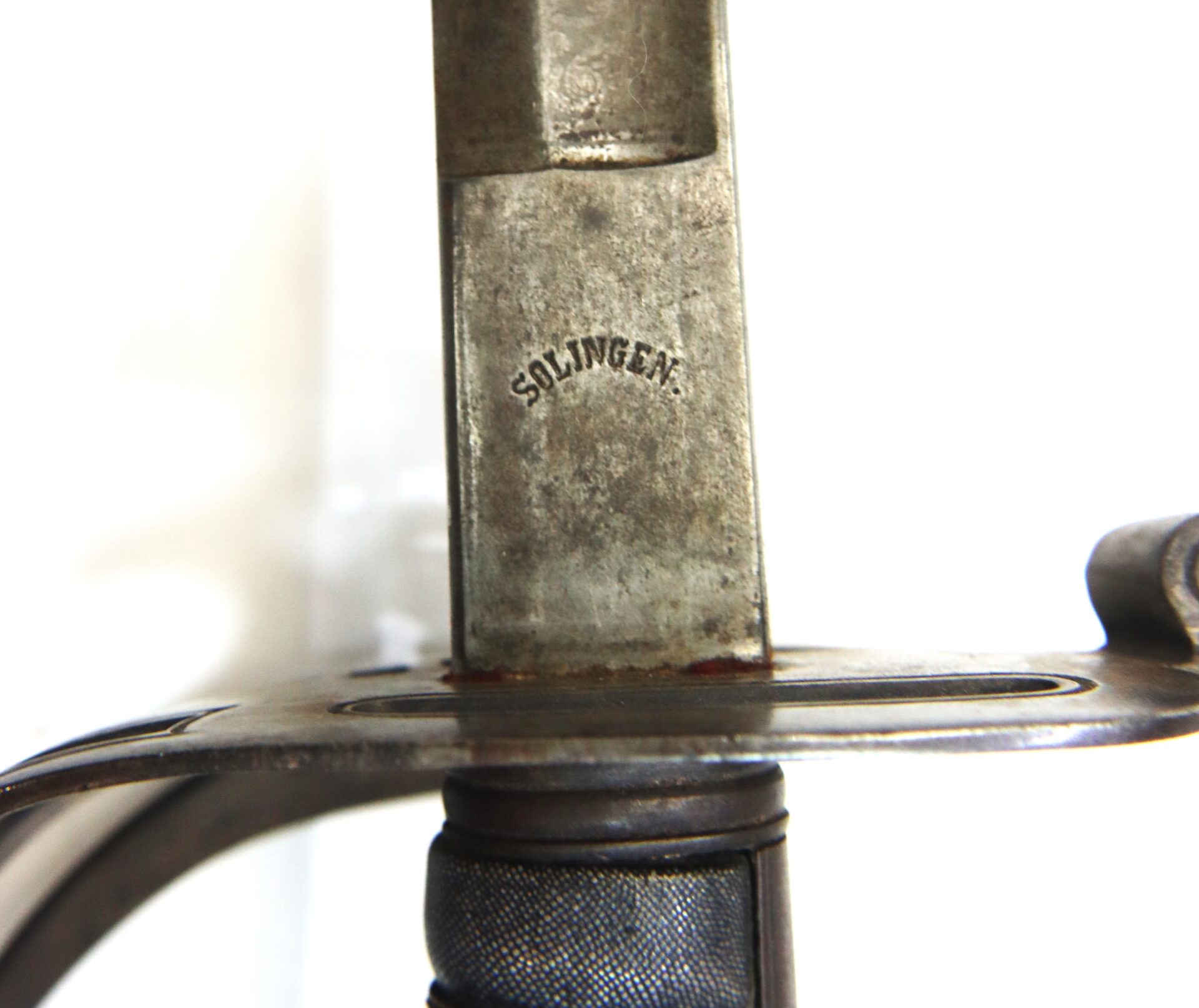Close-up of a sword hilt and blade, with the word "SOLINGEN" stamped on the metal near the guard.
