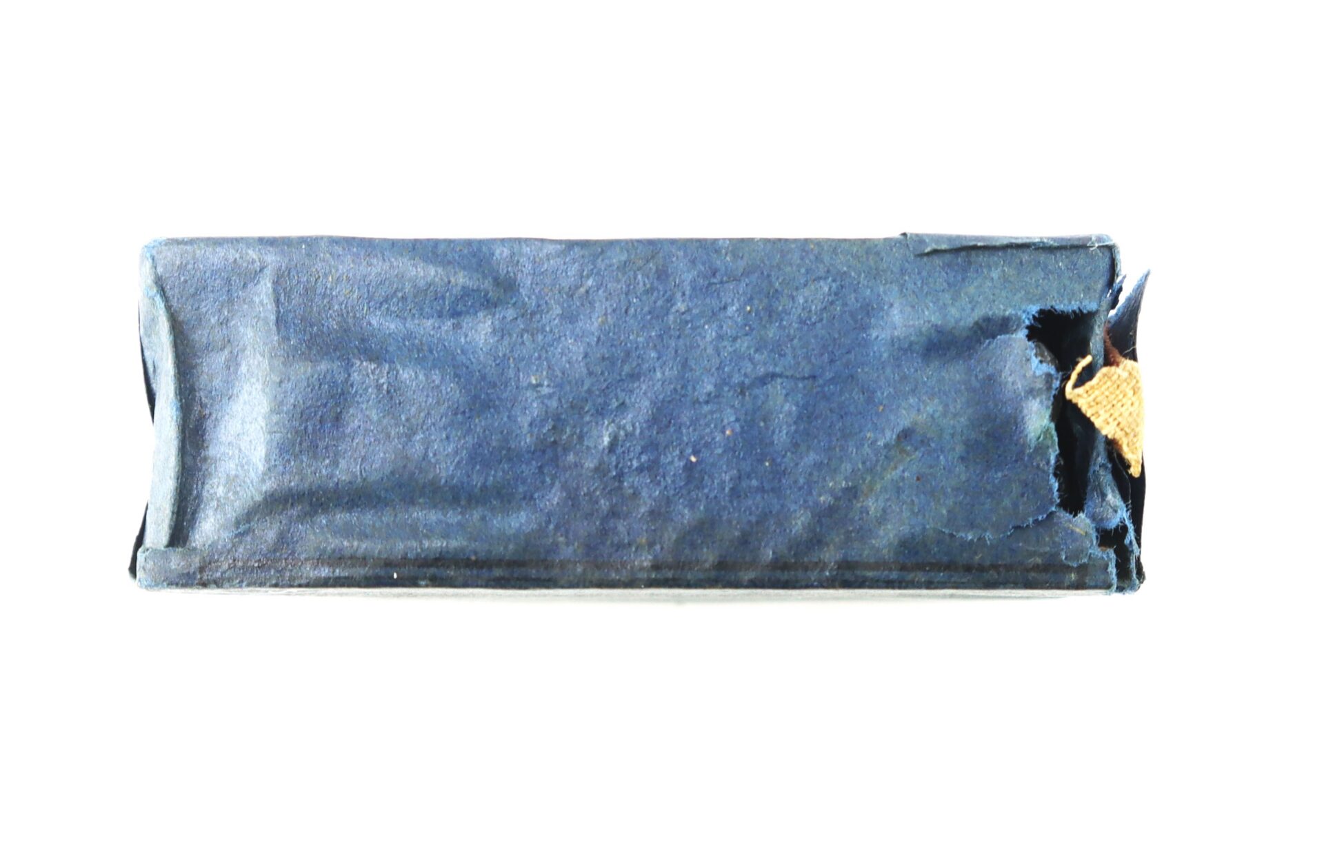 A rectangular object wrapped in dark blue paper with a small tear revealing gold foil underneath, shown against a white background.