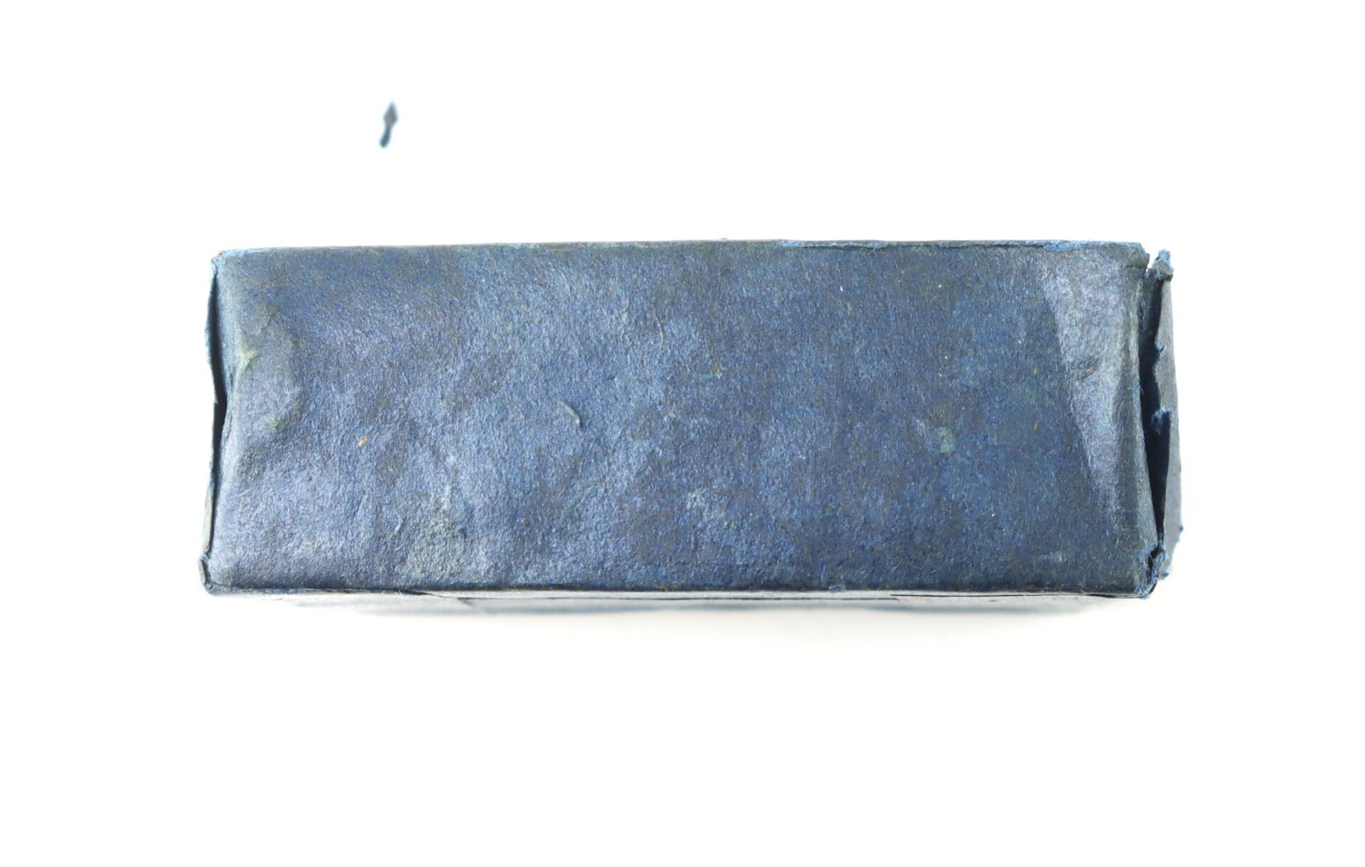A rectangular object wrapped in dark blue textured paper, viewed from above against a white background.