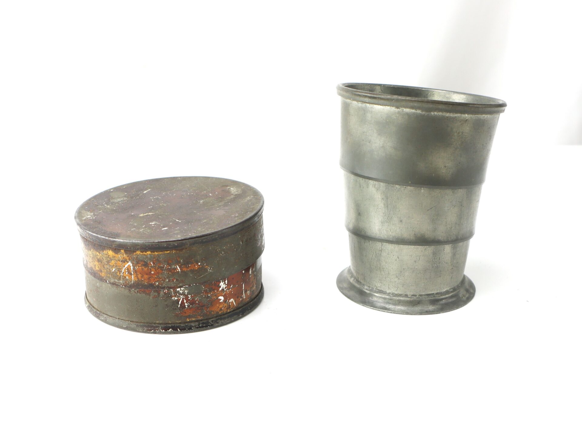 A metal collapsible cup is shown, with one image of the cup expanded and another image of it collapsed into a compact, circular case.