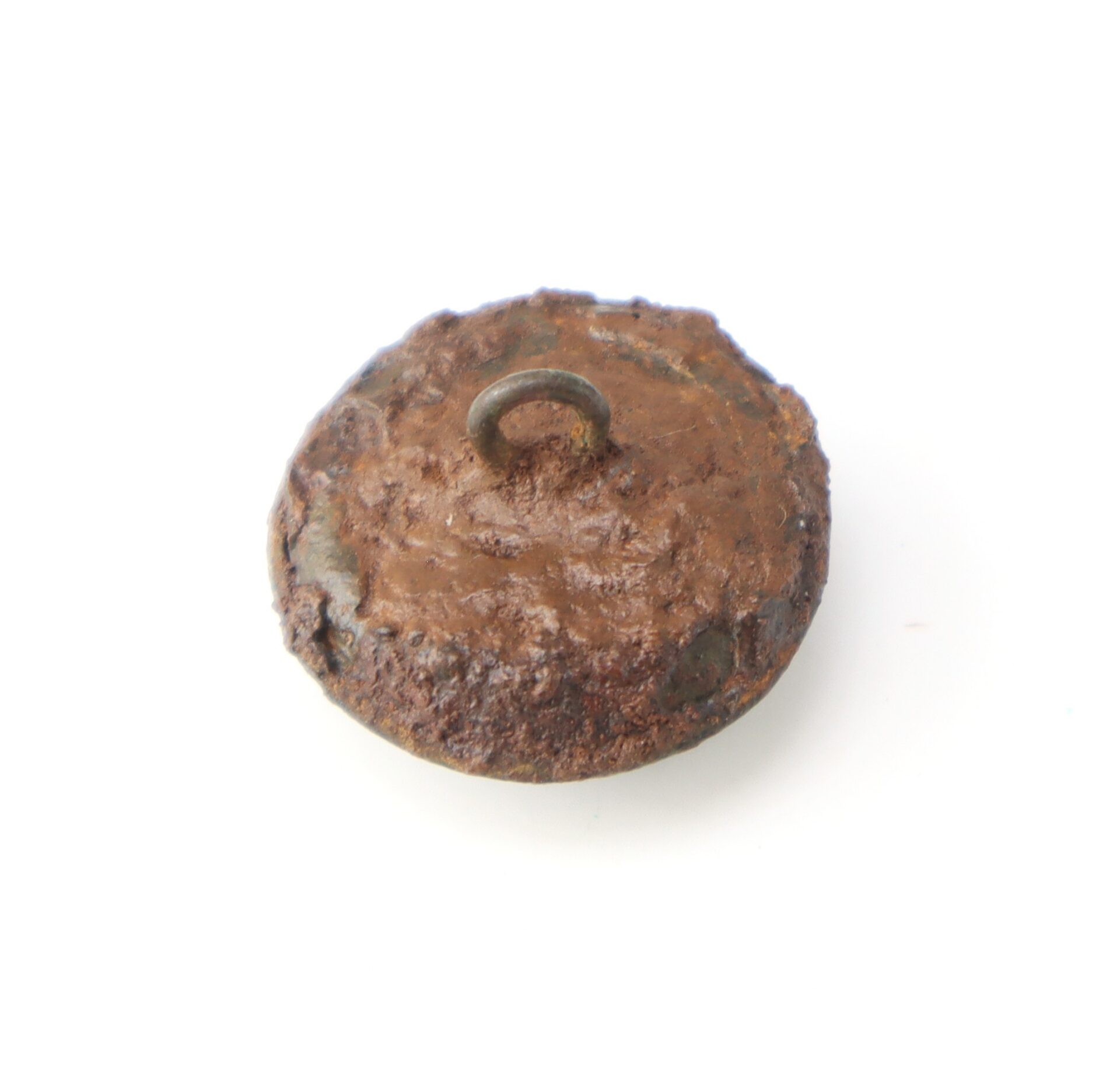 A rusty, round metal button with a loop shank on its back, photographed against a white background.