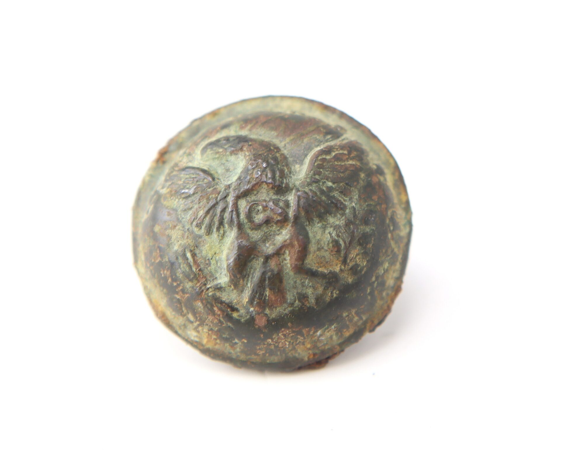 A round, worn bronze button with a raised design of an owl with spread wings on its front, set against a white background.