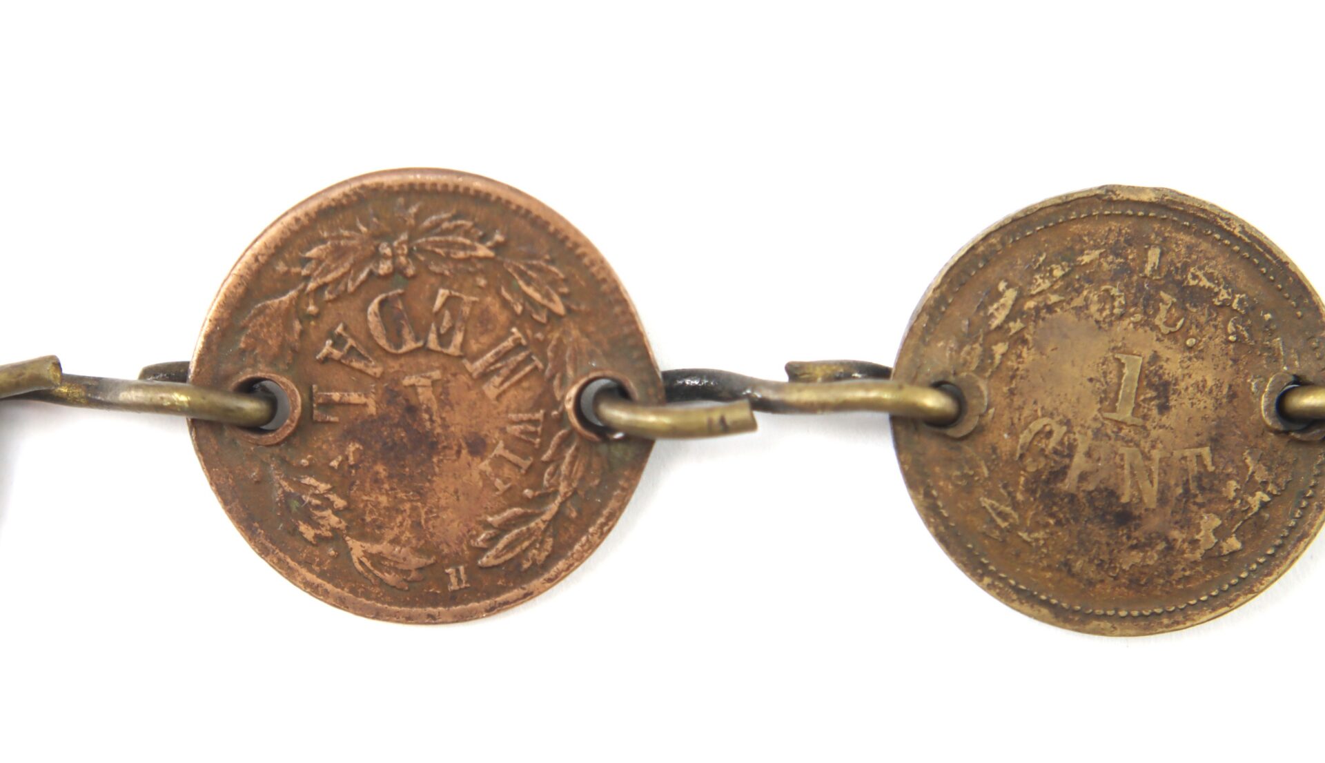 Two vintage one-cent coins are linked together with metal rings, forming part of a chain against a white background.