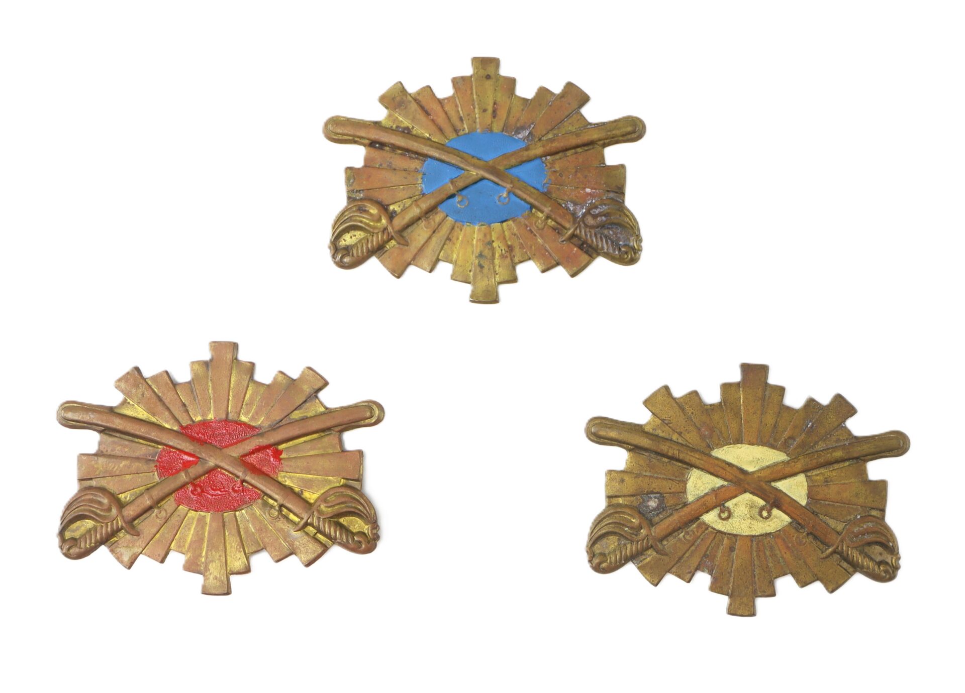 Three military insignia featuring crossed swords over starburst backgrounds, each with a different colored circle: blue (top), red (bottom left), and yellow (bottom right).