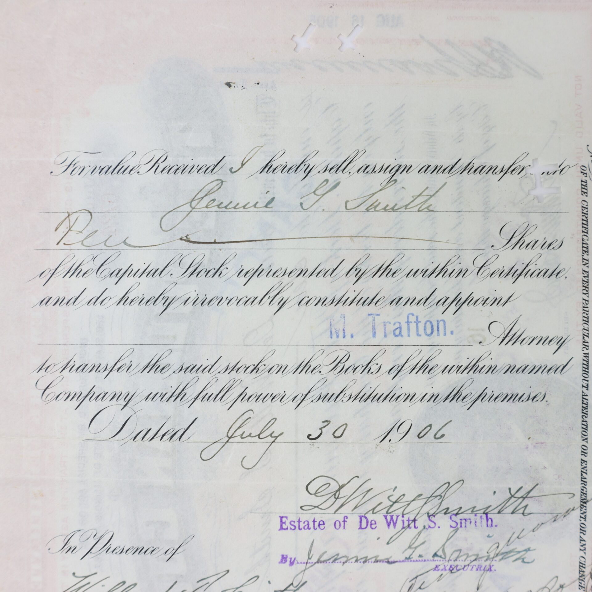 A handwritten 1906 stock transfer document assigning shares from Jennie E. Smith to M. I. Tratton, signed and dated July 30, 1906, with several signatures and a purple stamp.