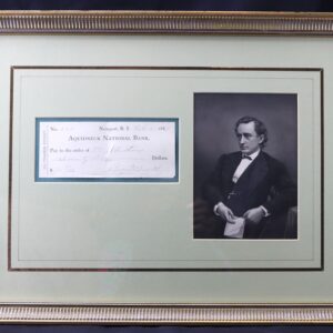 Framed display with an old bank check from Aquidneck National Bank on the left and a black-and-white portrait of a man in formal attire on the right.