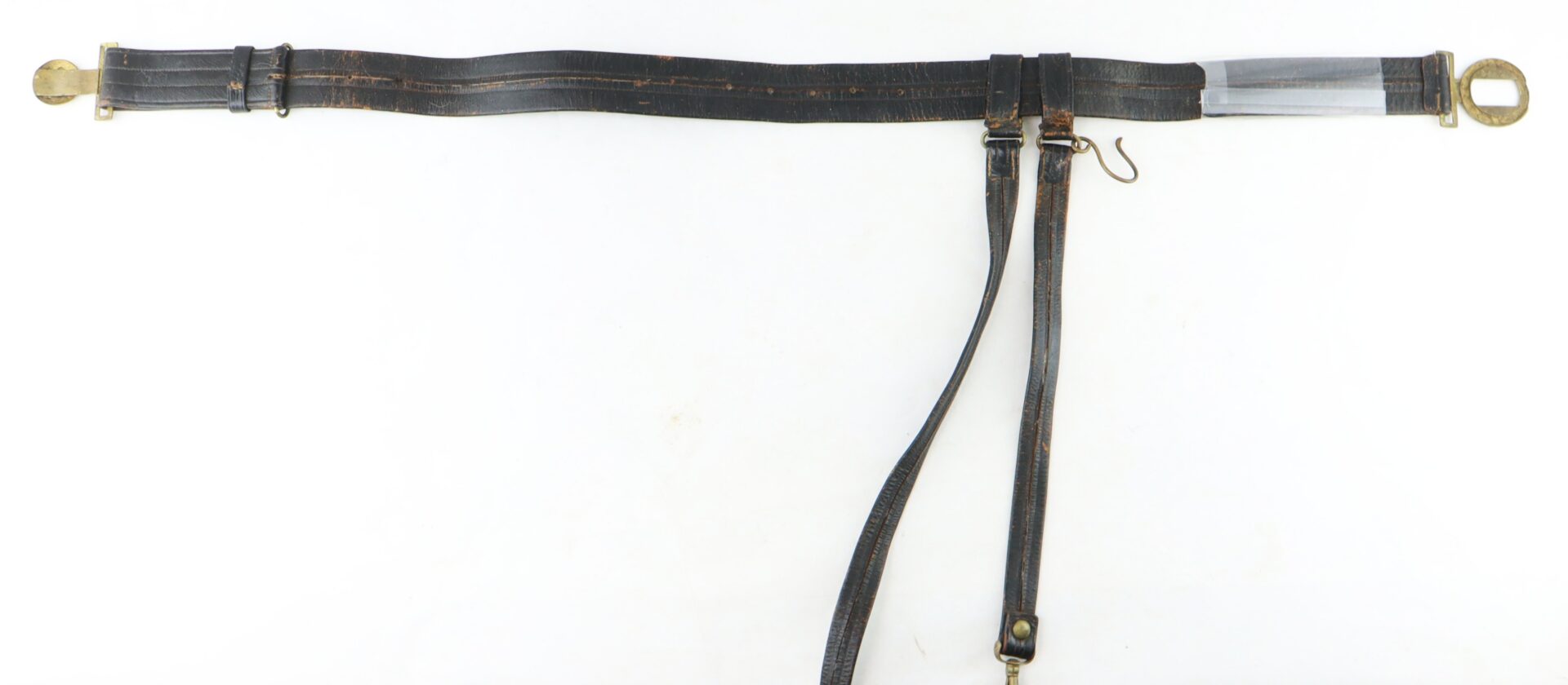 A vintage leather horse harness strap with brass fittings, a metal hook, and adjustable leather straps, laid out flat on a white background.
