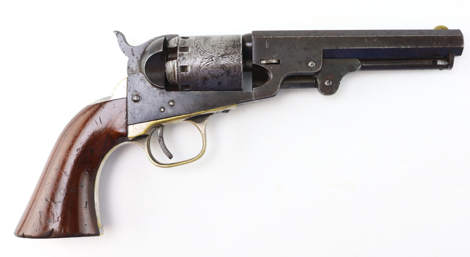 Antique revolver with a wooden grip, brass trigger guard, and metal barrel, displayed on a white background.
