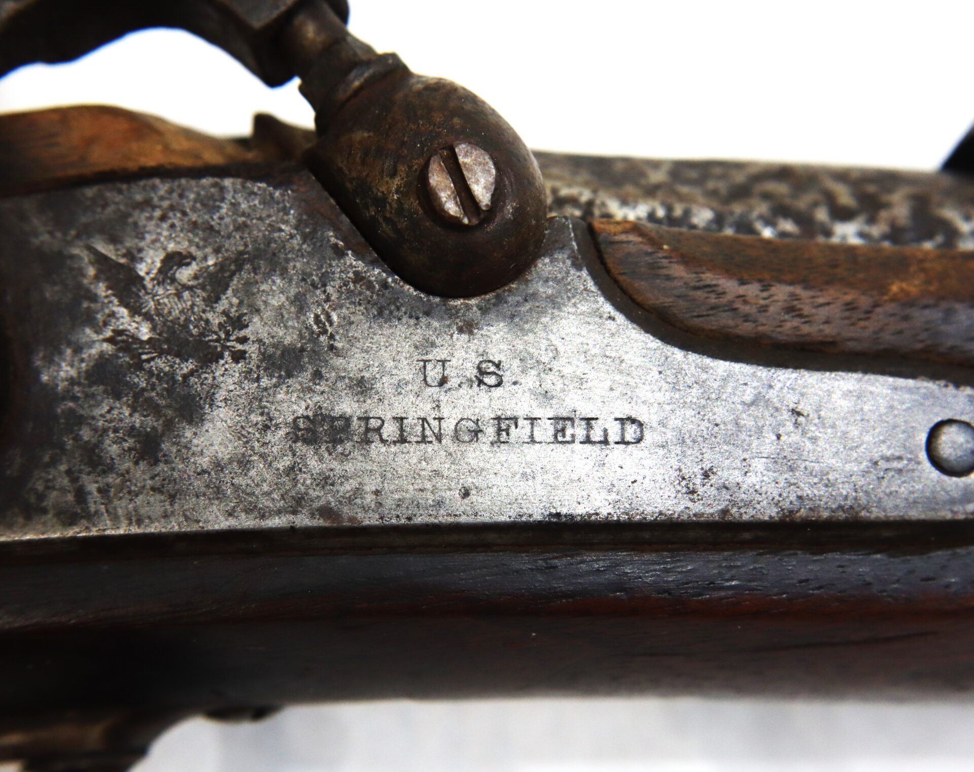 Close-up of a metal rifle part stamped with "U.S. SPRINGFIELD," showing some rust and wear on the surface.