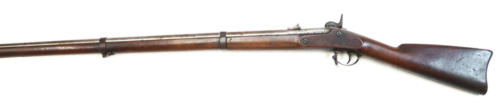 Antique wooden-stock rifle with a long barrel, metal firing mechanism, and trigger guard, displayed on a white background.
