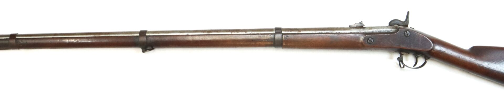 A vintage, single-shot, percussion cap rifle with a long wooden stock and metal barrel, viewed from the side on a white background.