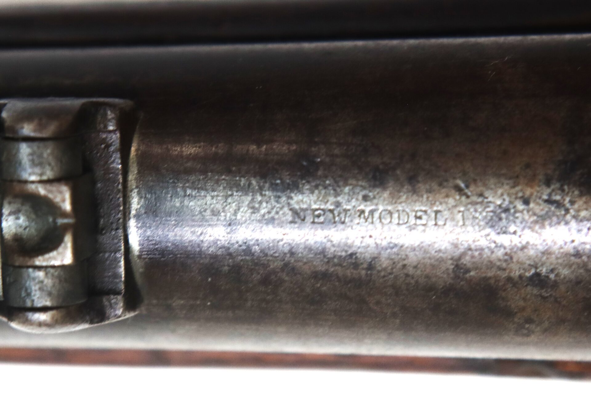 Close-up image of a metal firearm barrel with the engraved text "NEW MODEL" visible on the surface.