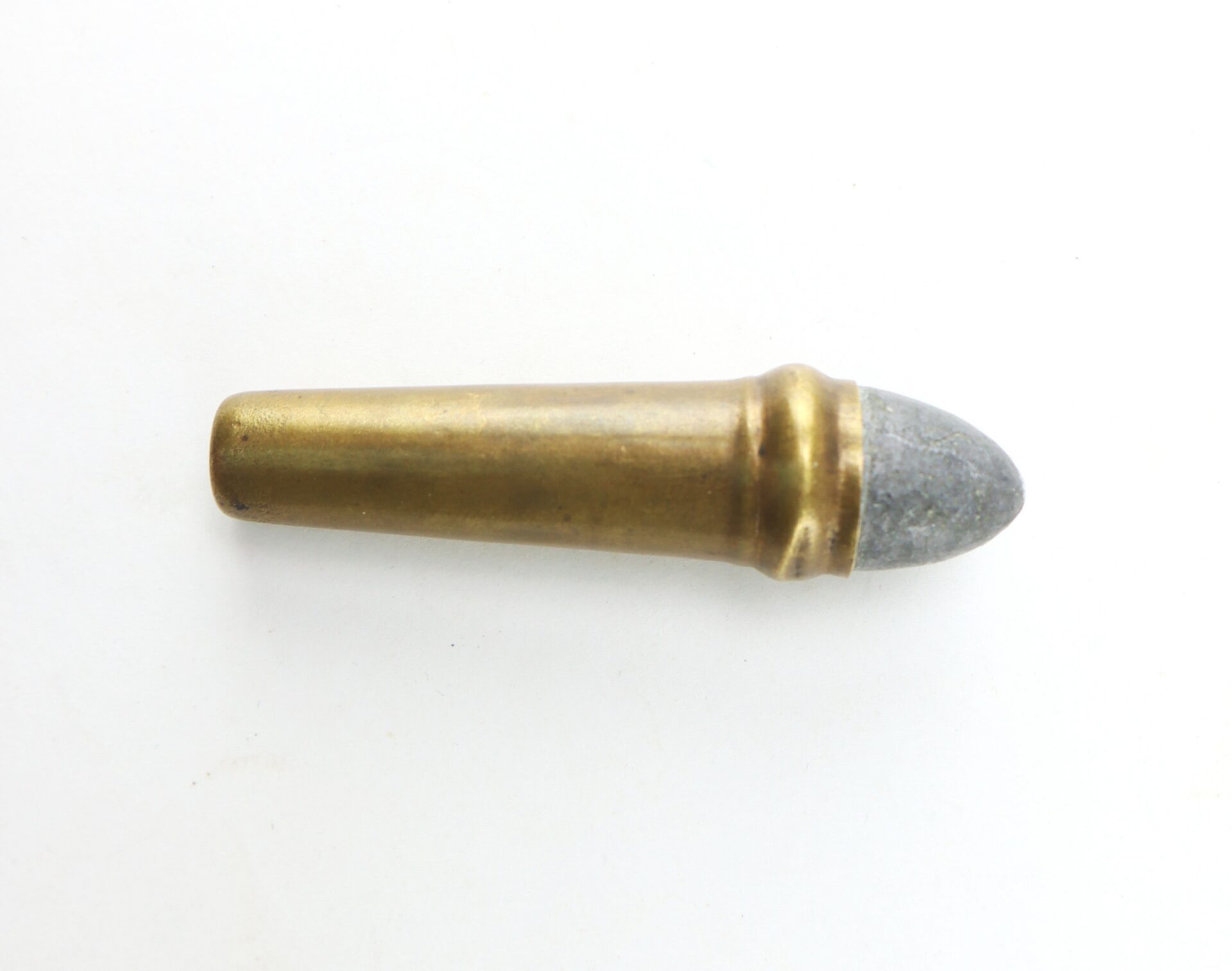 A single brass and lead bullet cartridge lying on a white background.