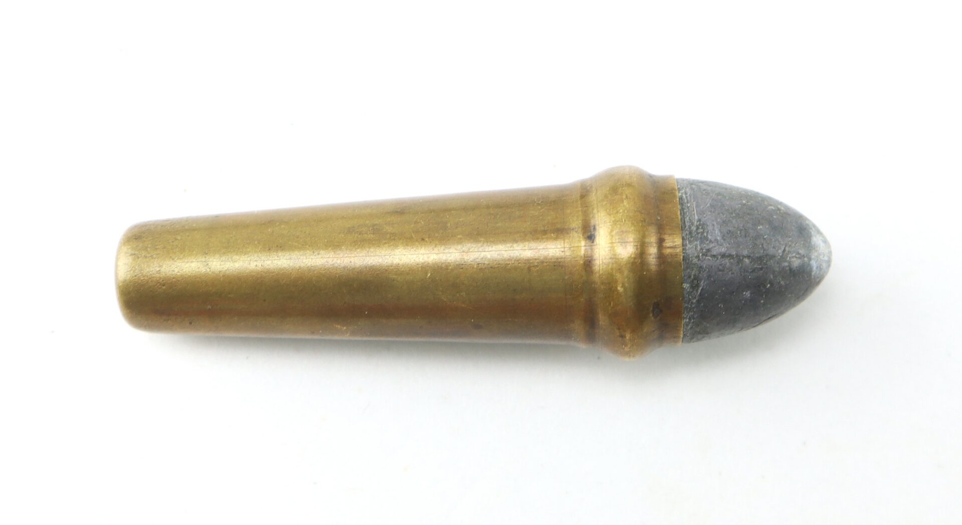 A single brass and lead bullet cartridge lies horizontally on a white background.