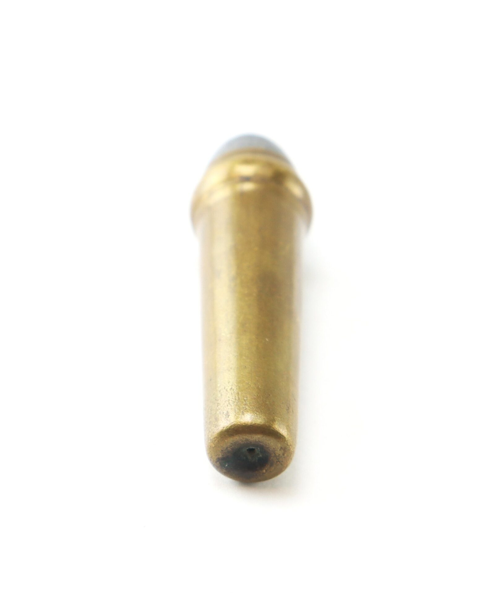 A single brass bullet cartridge lying on a white background, viewed from the base.