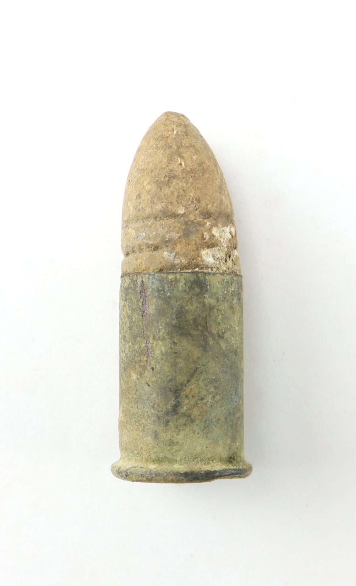 A weathered, discolored bullet with a rounded tip and visible signs of age, photographed against a plain white background.