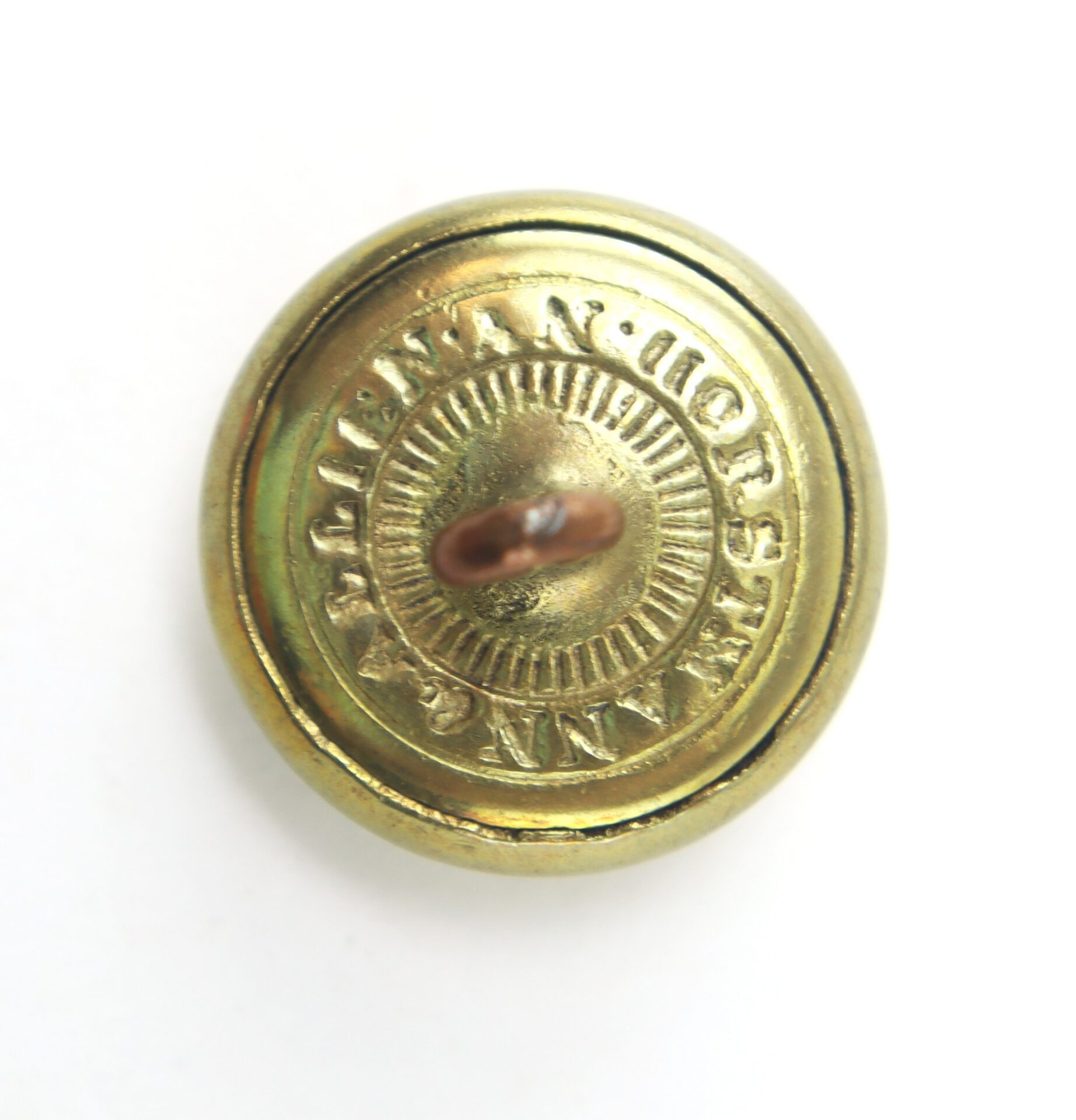Gold metal button with a raised shank and the inscription "WATERBURY BUTTON CO. CONN." engraved around the edge on the back.