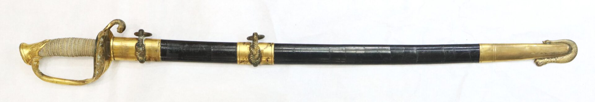 A decorative sword with a gold-colored hilt and guard, a black scabbard with gold accents, and a textured grip, displayed on a white background.