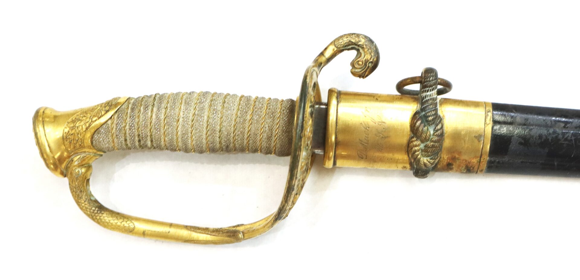 A close-up of an ornately decorated sword hilt with a gold guard, wrapped grip, and part of a black scabbard featuring gold fittings and a snake motif.