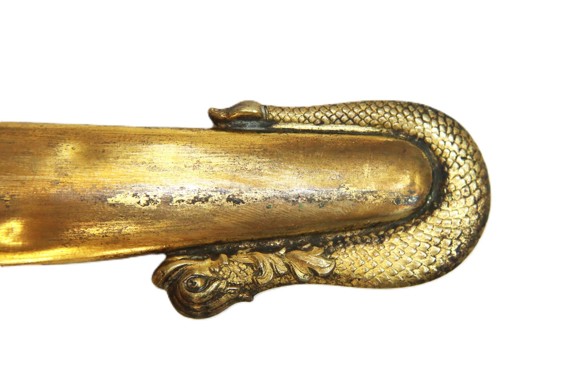 Gold sword hilt with an ornate design shaped like a coiled snake, featuring detailed scales and a sculpted head on a plain white background.