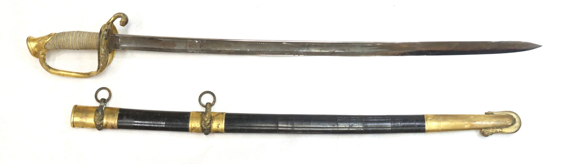 A ceremonial sword with an ornate gold hilt and guard, shown above its black and gold scabbard with two mounting rings.