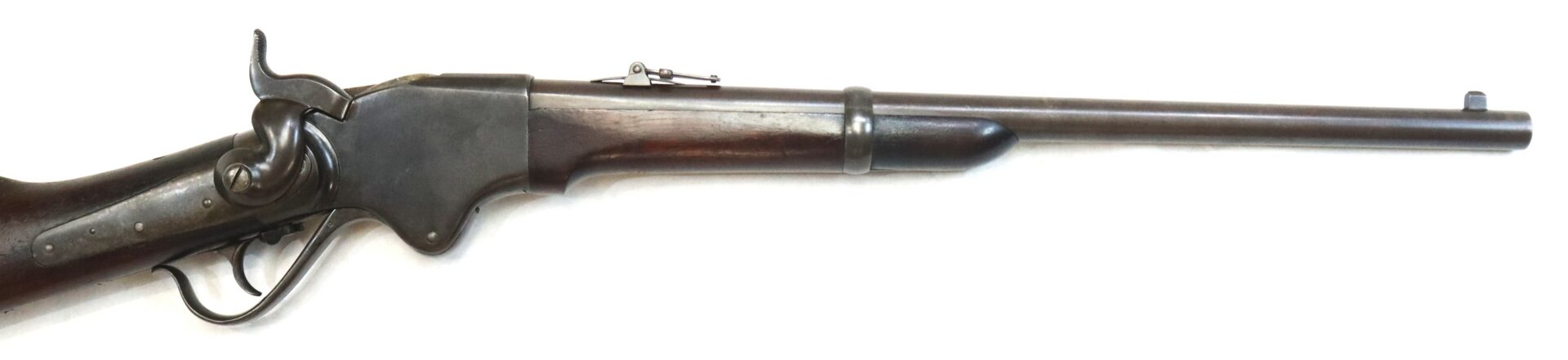 Side view of an antique lever-action rifle with a wooden stock and metal barrel, photographed against a plain white background.