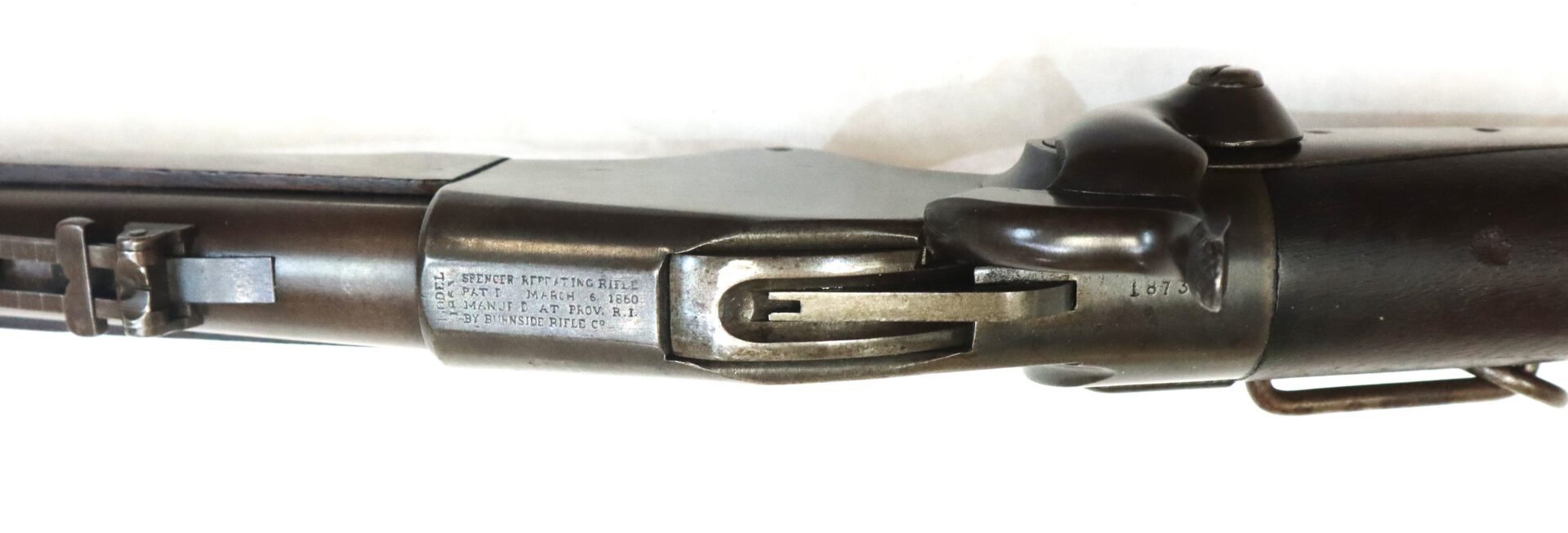 Close-up view of the receiver and locking mechanism of an antique Springfield Model 1873 trapdoor rifle, showing serial number and patent markings.