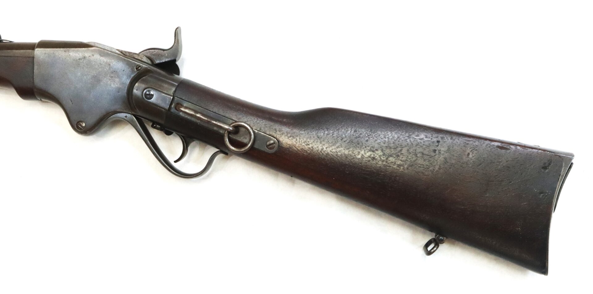 Partial view of an old lever-action rifle with a wooden stock and metal receiver, displayed on a white background.