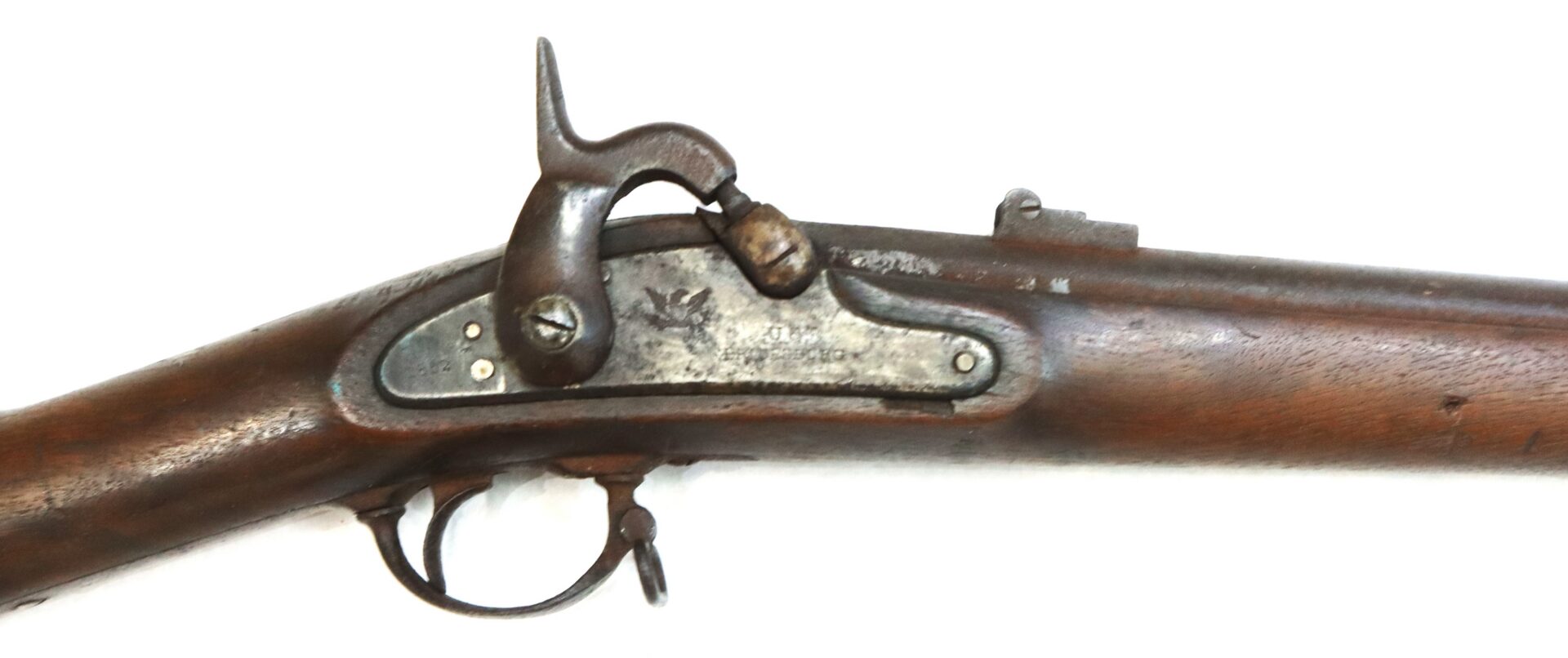 Close-up view of an antique percussion cap rifle, showing the lock mechanism, trigger, and part of the wooden stock against a white background.