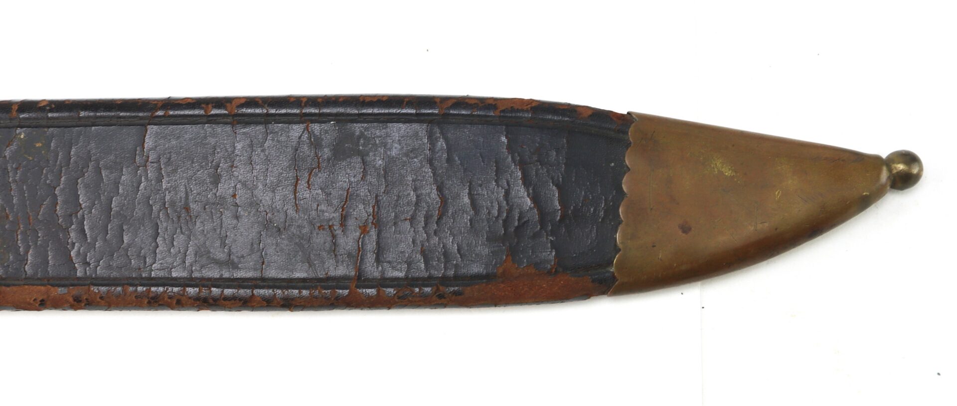 Close-up of an aged, dark leather sword scabbard with a worn brass tip, showing signs of wear and surface cracking.