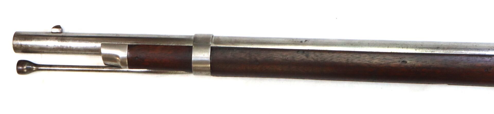 Close-up of the barrel and wooden stock of a bolt-action rifle, showing the bolt handle and metal barrel band against a white background.