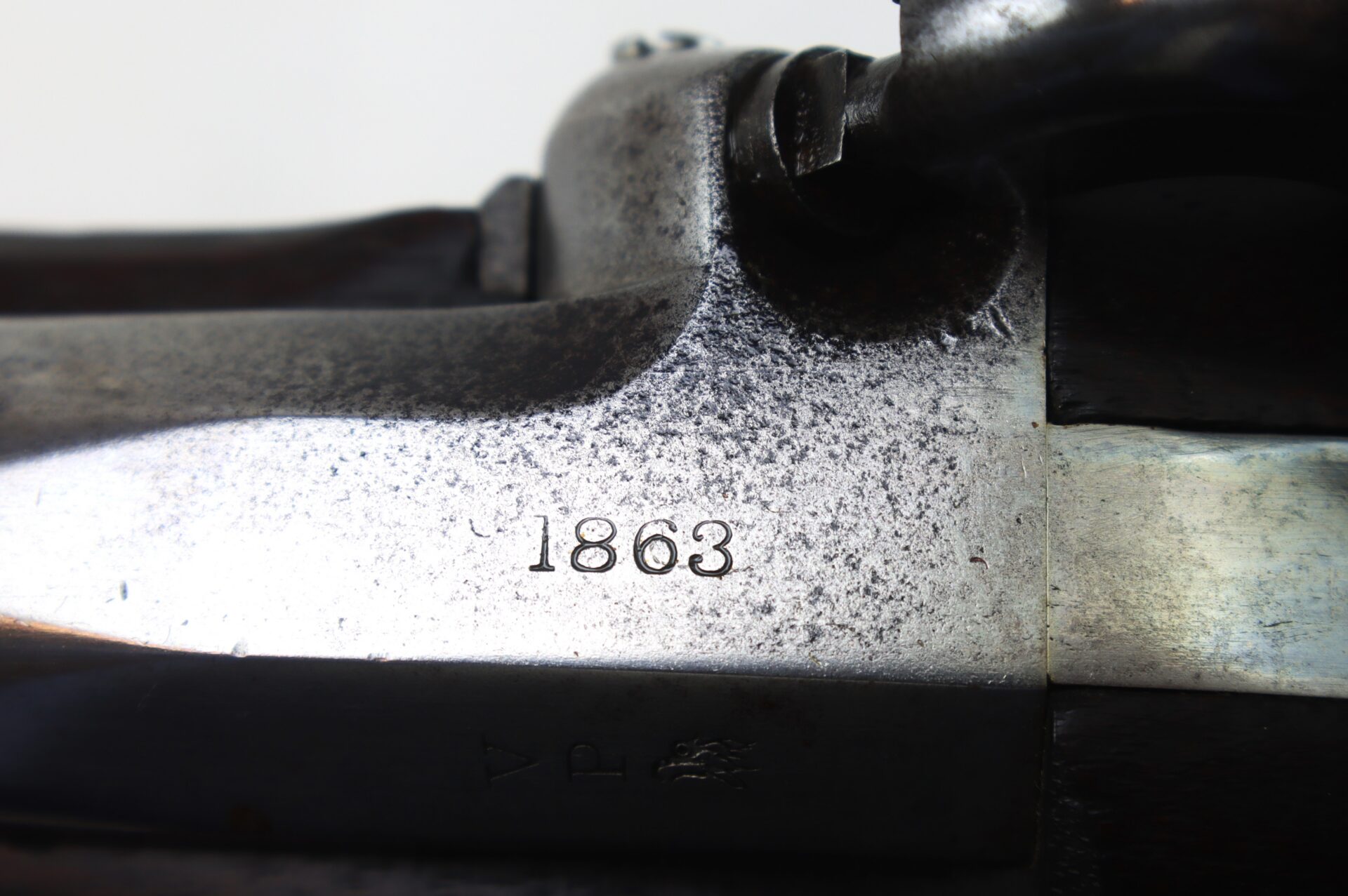 Close-up of an engraved "1863" marking on the metal surface of an antique firearm, with visible texture and aging.