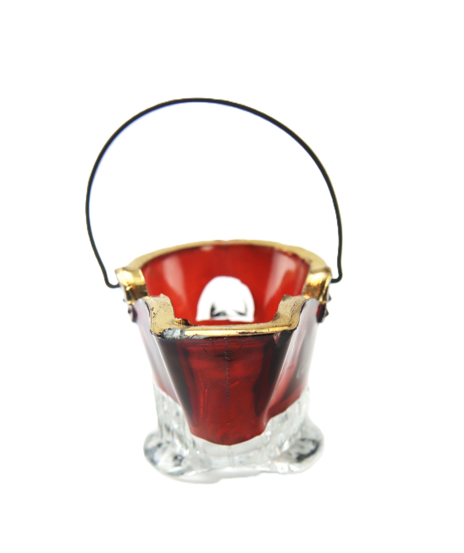 Red and clear glass bucket ornament with a gold rim and a thin black handle, placed against a white background.