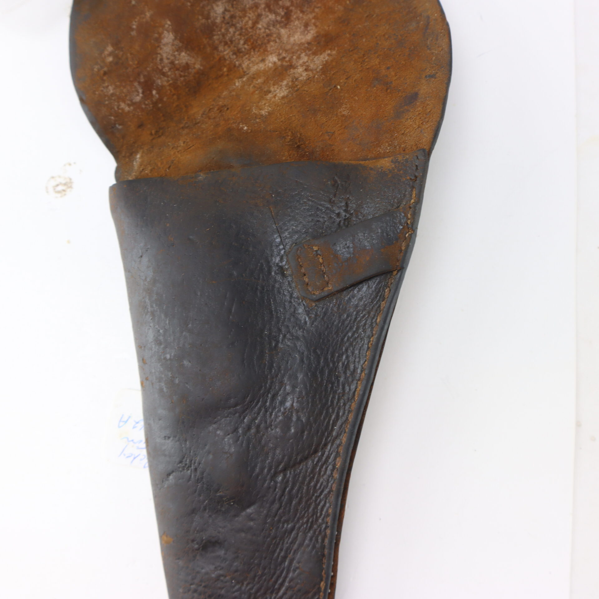 A worn, brown leather holster with visible creases and stitching, partially open to show the interior.