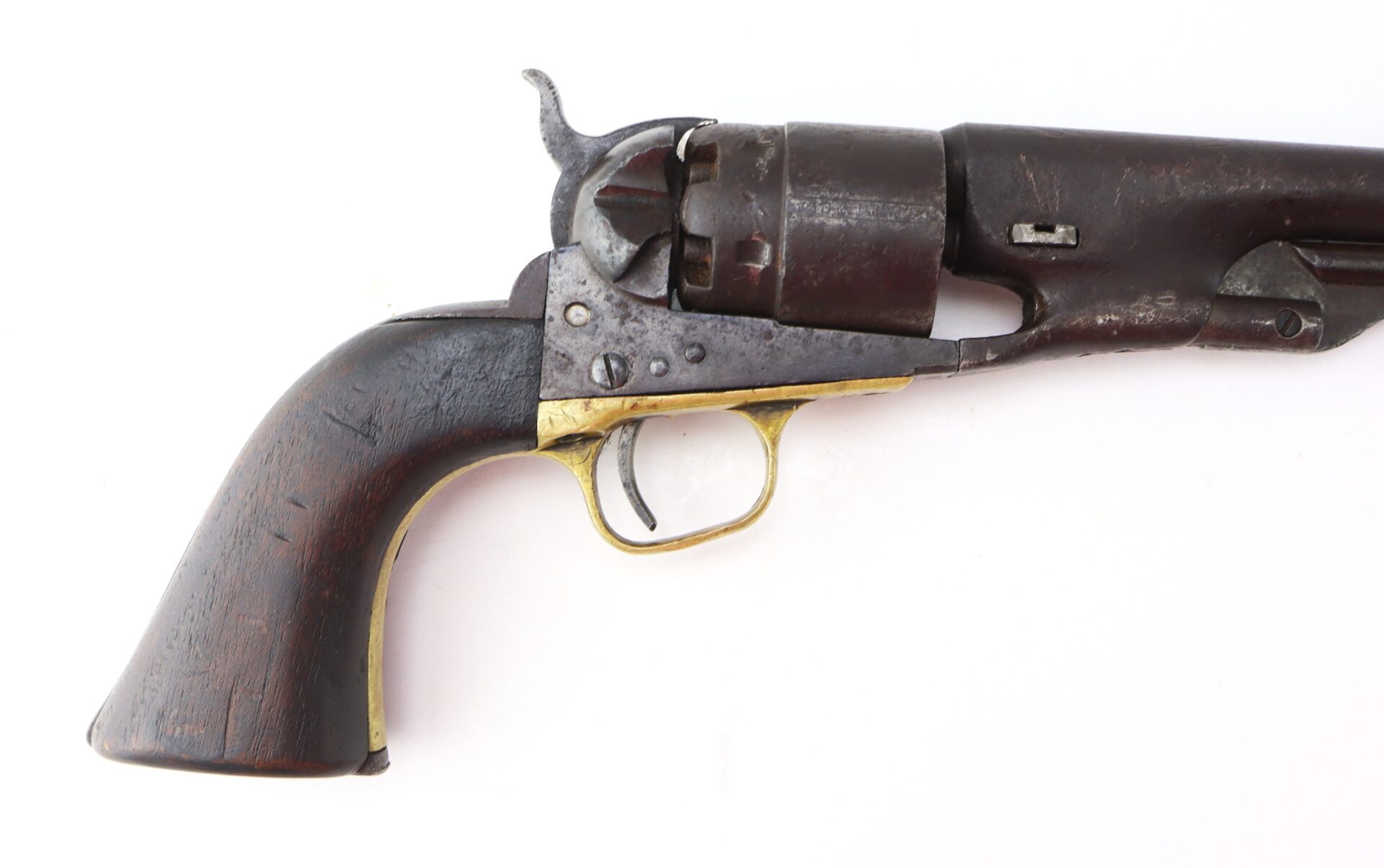 Old revolver with a wooden grip, brass trigger guard, and a dark metal barrel and cylinder, shown against a white background.