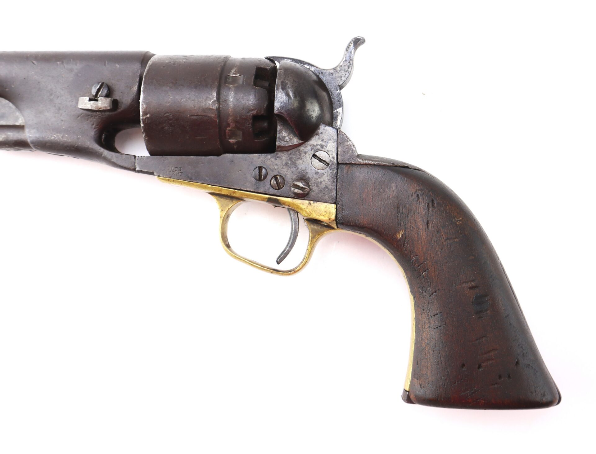 Close-up of an antique revolver with a wooden grip, brass trigger guard, and dark metal barrel against a white background.