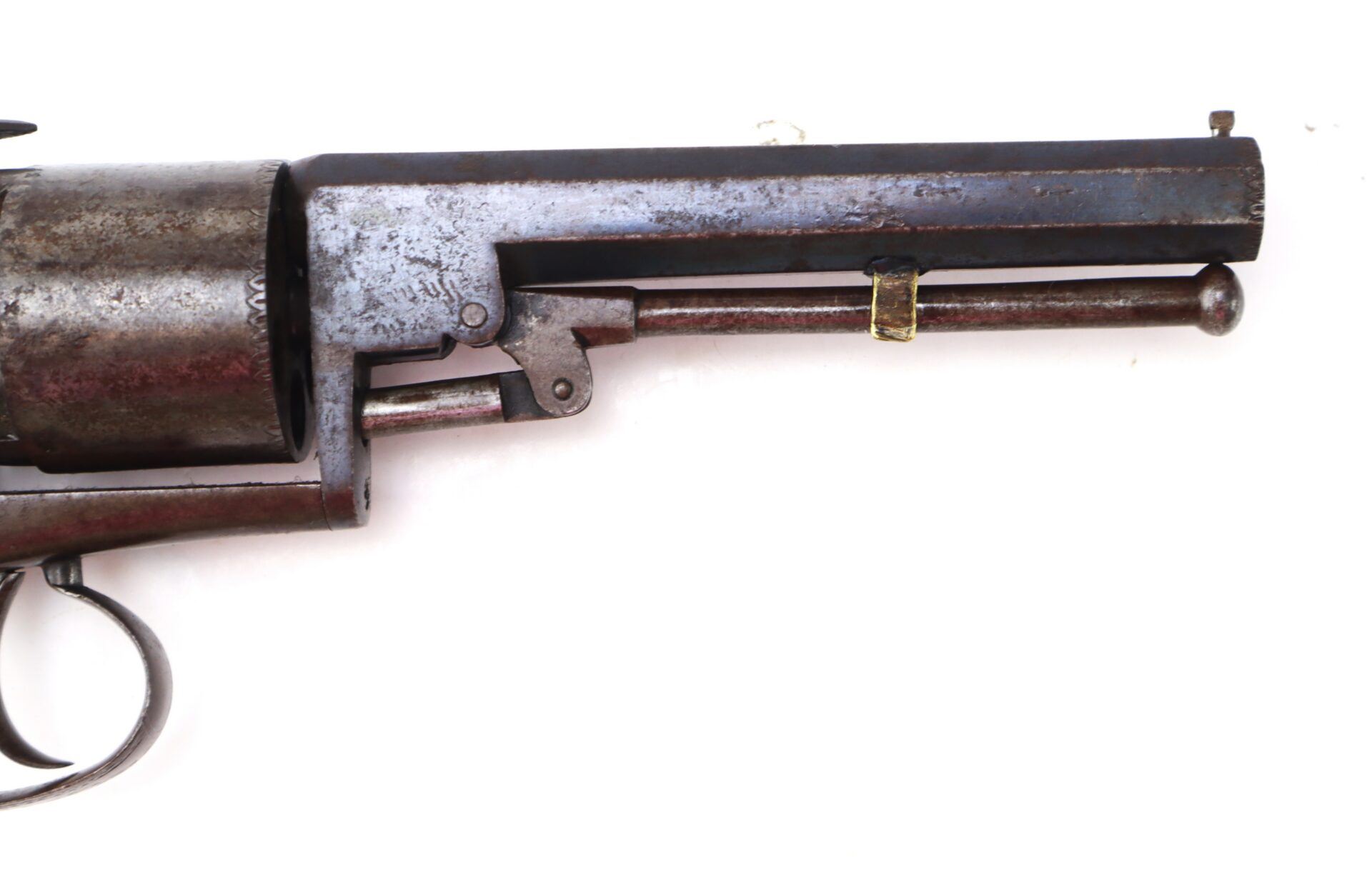 Close-up of an old, rusty revolver focused on the barrel and trigger against a white background.