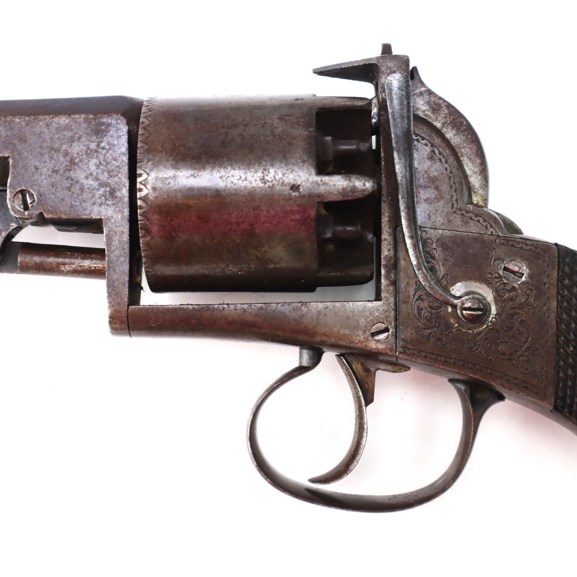 Close-up of an old, worn metal revolver showing the trigger, cylinder, and part of the grip, set against a plain white background.