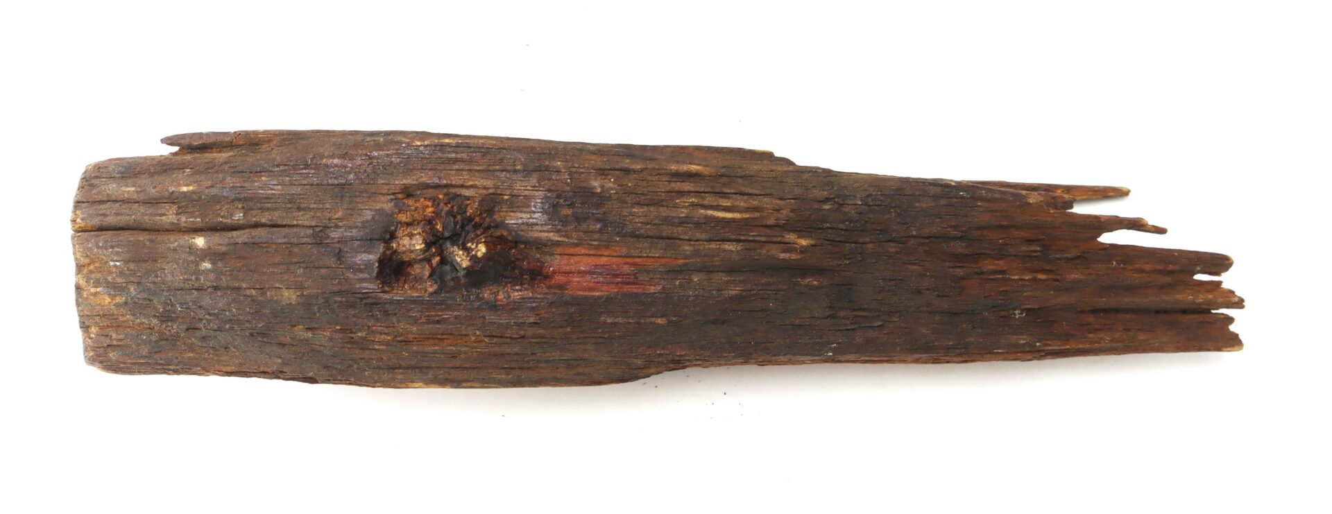 A piece of old, weathered wood with a rough surface and jagged edges, photographed on a white background.