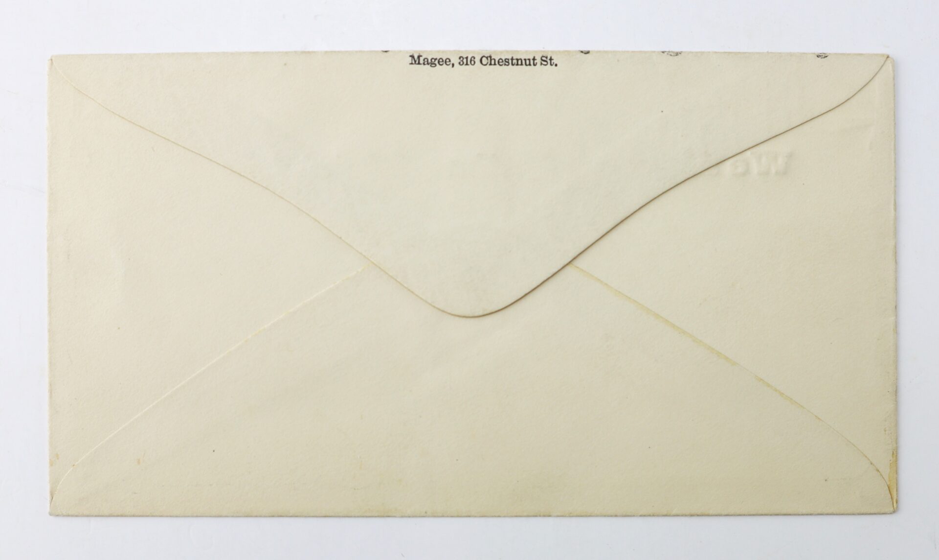 A closed cream-colored envelope, shown from the back, with “Magee, 316 Chestnut St.” printed near the top flap.