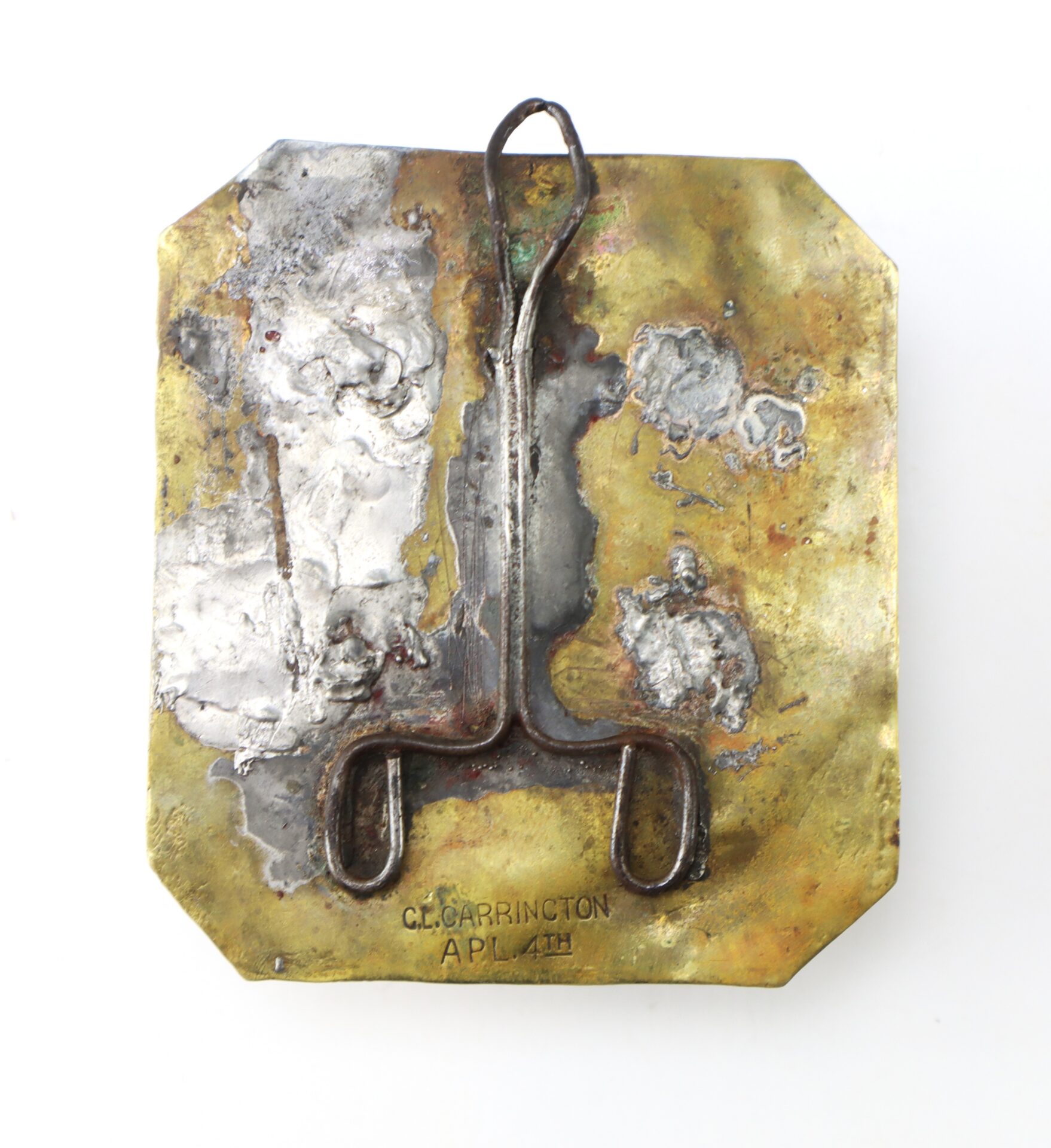 A brass and metal object with soldered joints, featuring a hook-like structure and engraved text reading “C.L. CARRINGTON APL 4TH.”.