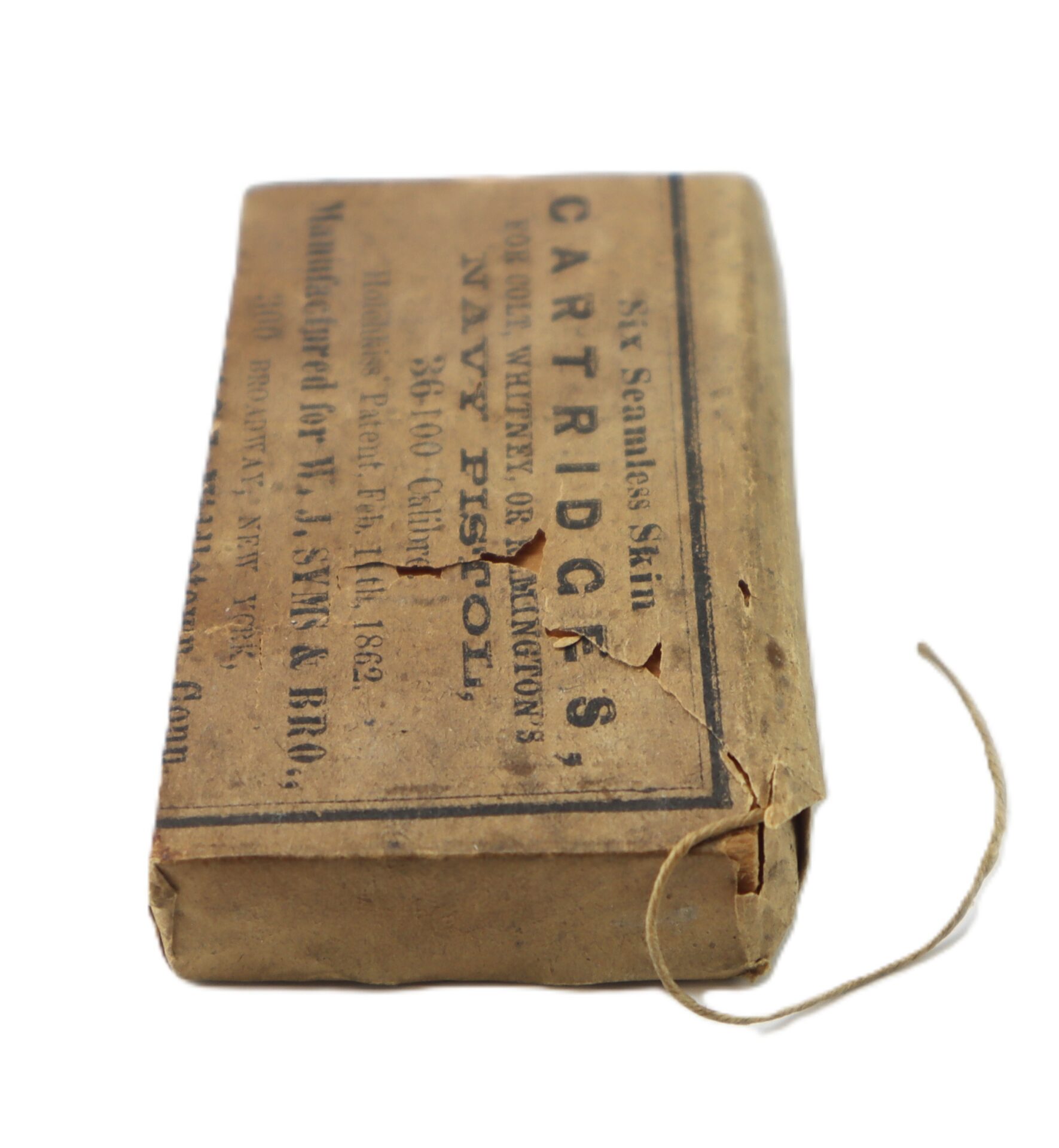 A vintage brown paper cartridge box labeled for Navy pistol ammunition, with printed text and a string looped out of one corner.